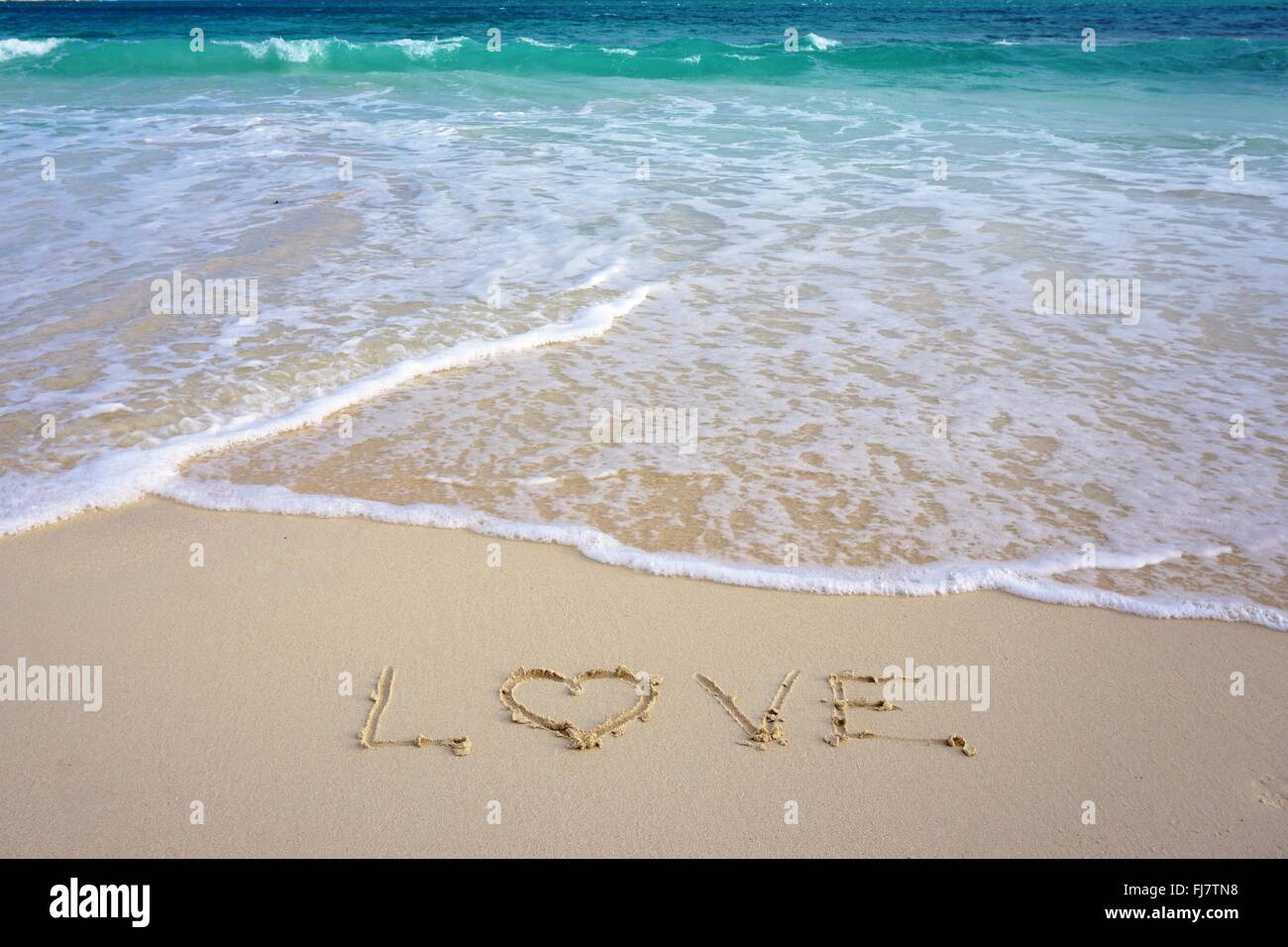 "Love" written in the sand on the beach Stock Photo - Alamy