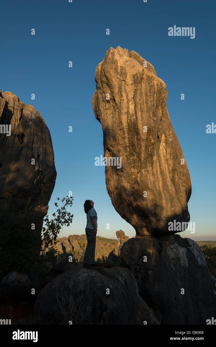 Balancing rock with a person as scale in the Chillagoe-Mungana Caves National Park. Stock Photo
