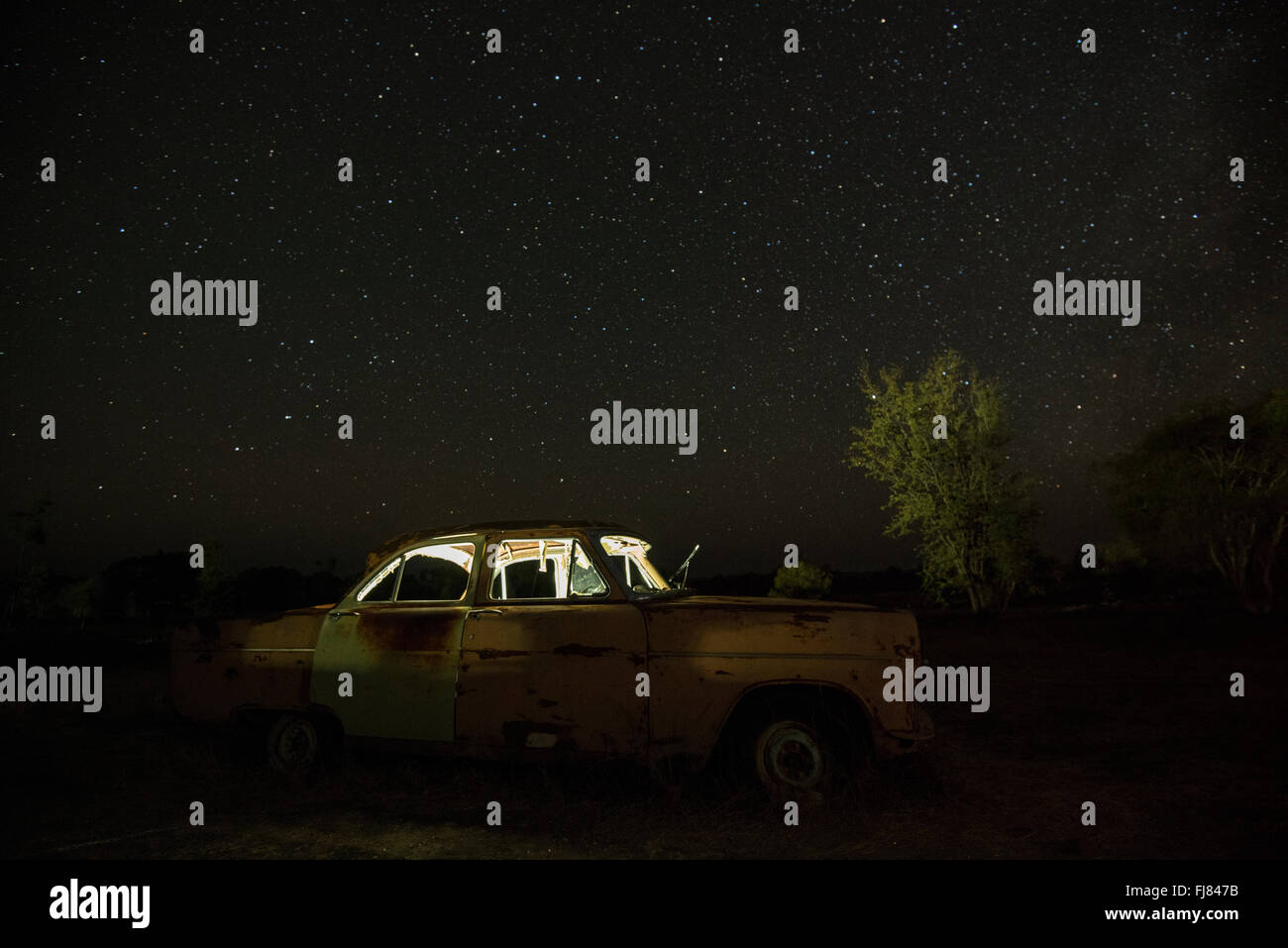 Milky Way over old decommissioned Ford cars in a collector's backyard in outback Chillagoe. Stock Photo