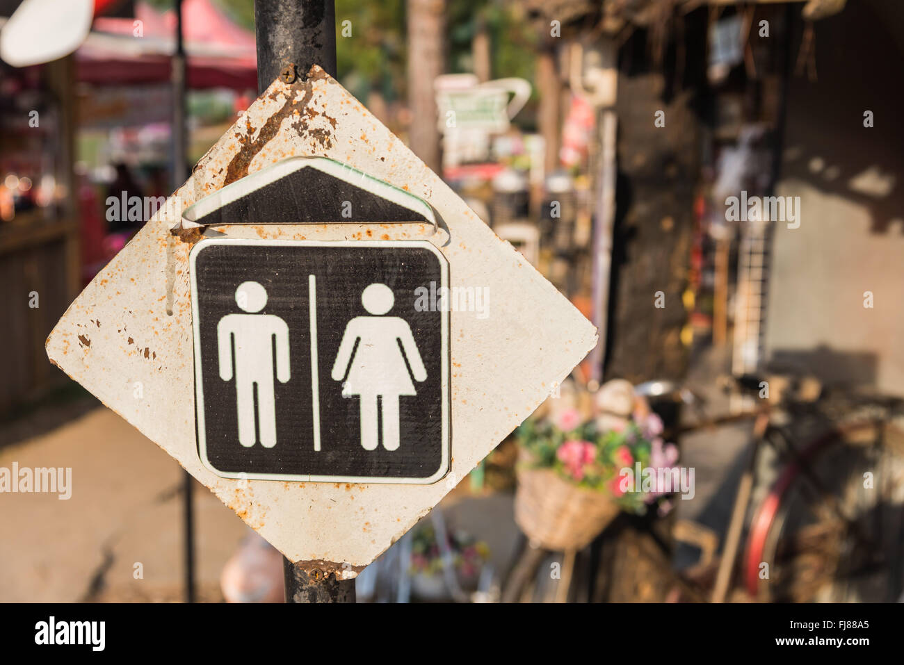 The rusty restroom sign on column Stock Photo - Alamy