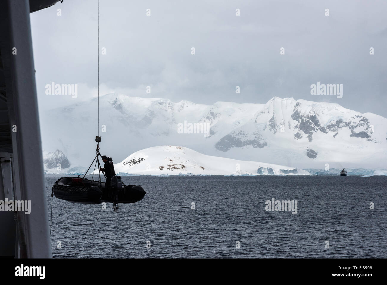 Inflatable zodiac boat lowered from cruise ship in Antarctica, with