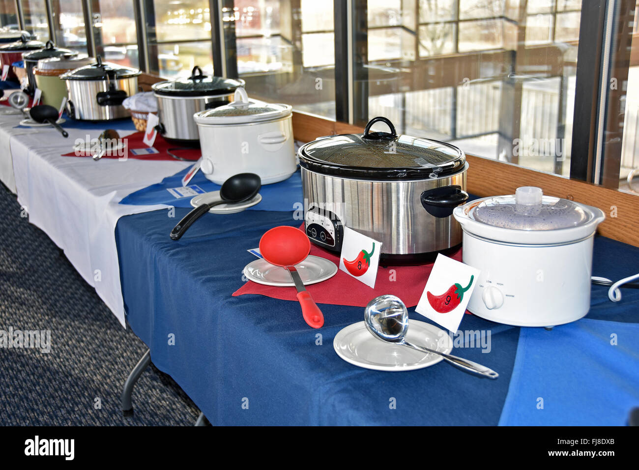Row of crock pots in a chili cook off contest in restaurant. Stock Photo