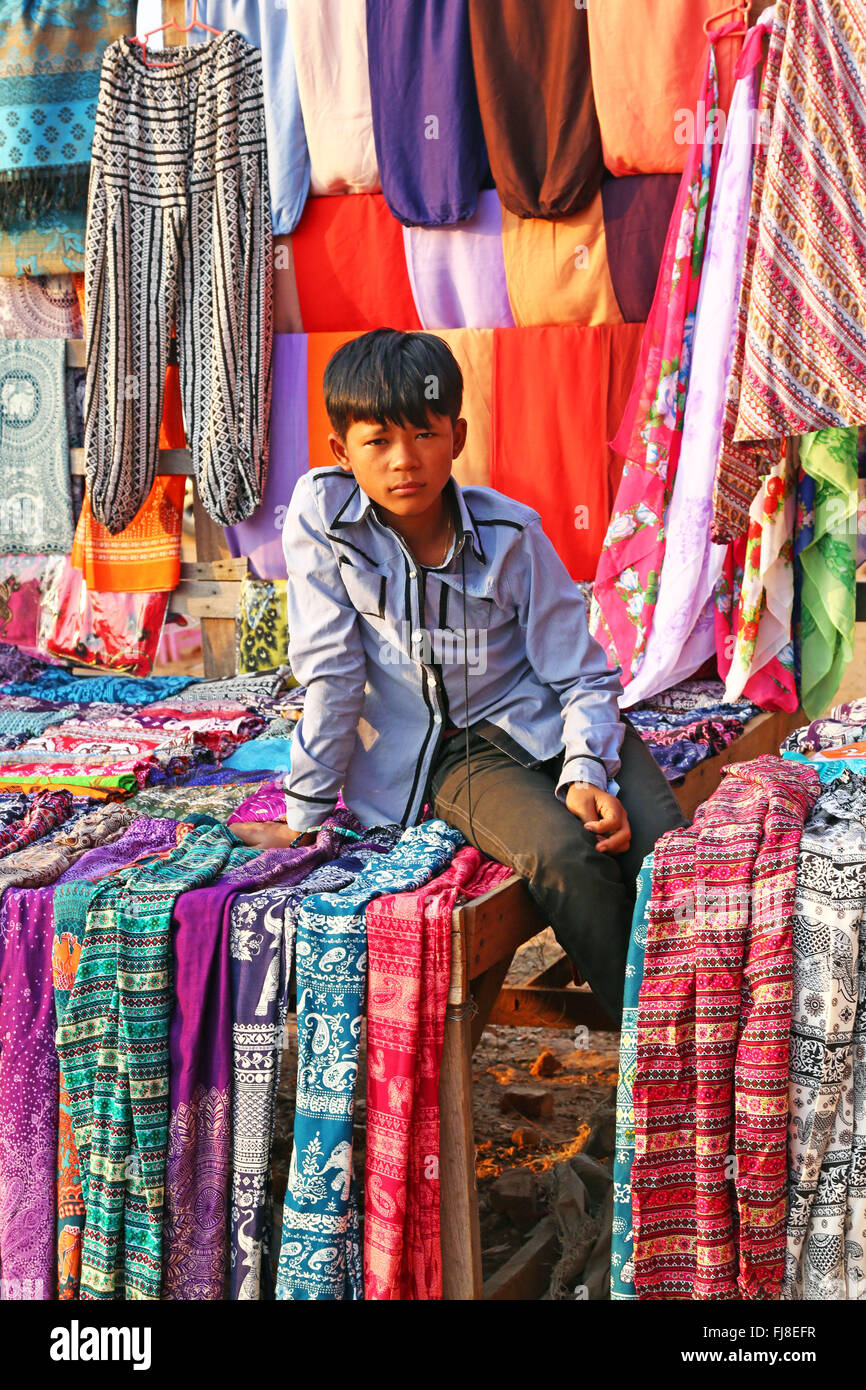 Boy on a trouser and clothing stall at Pyathadar Hpaya Temple Pagoda on the Plain of Bagan, Bagan, Myanmar (Burma) Stock Photo
