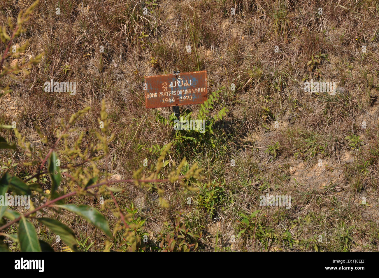 Bomb sign : Bomb crater at the Plain of Jars site 1, Xieng Khuang Province, Laos, Southeast Asia Stock Photo