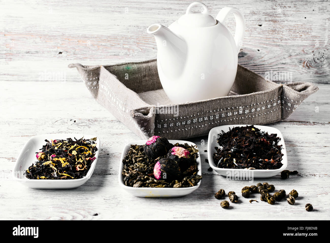 Set of different varieties of oriental tea on bright wooden background ...