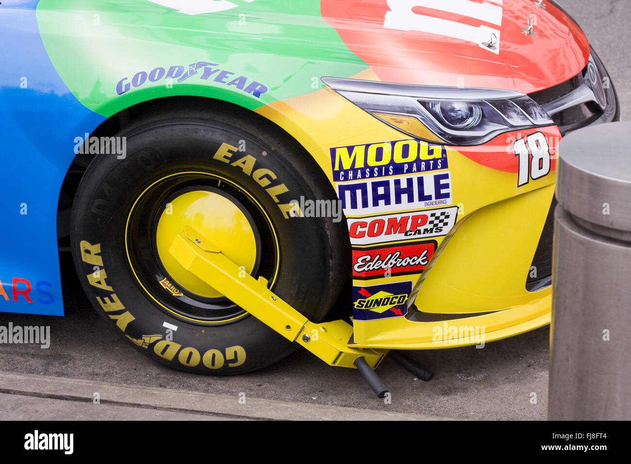 NASCAR Racecar parked on the street with an immobilization boot on the right front Goodyear Eagle D4470 racing tire Stock Photo