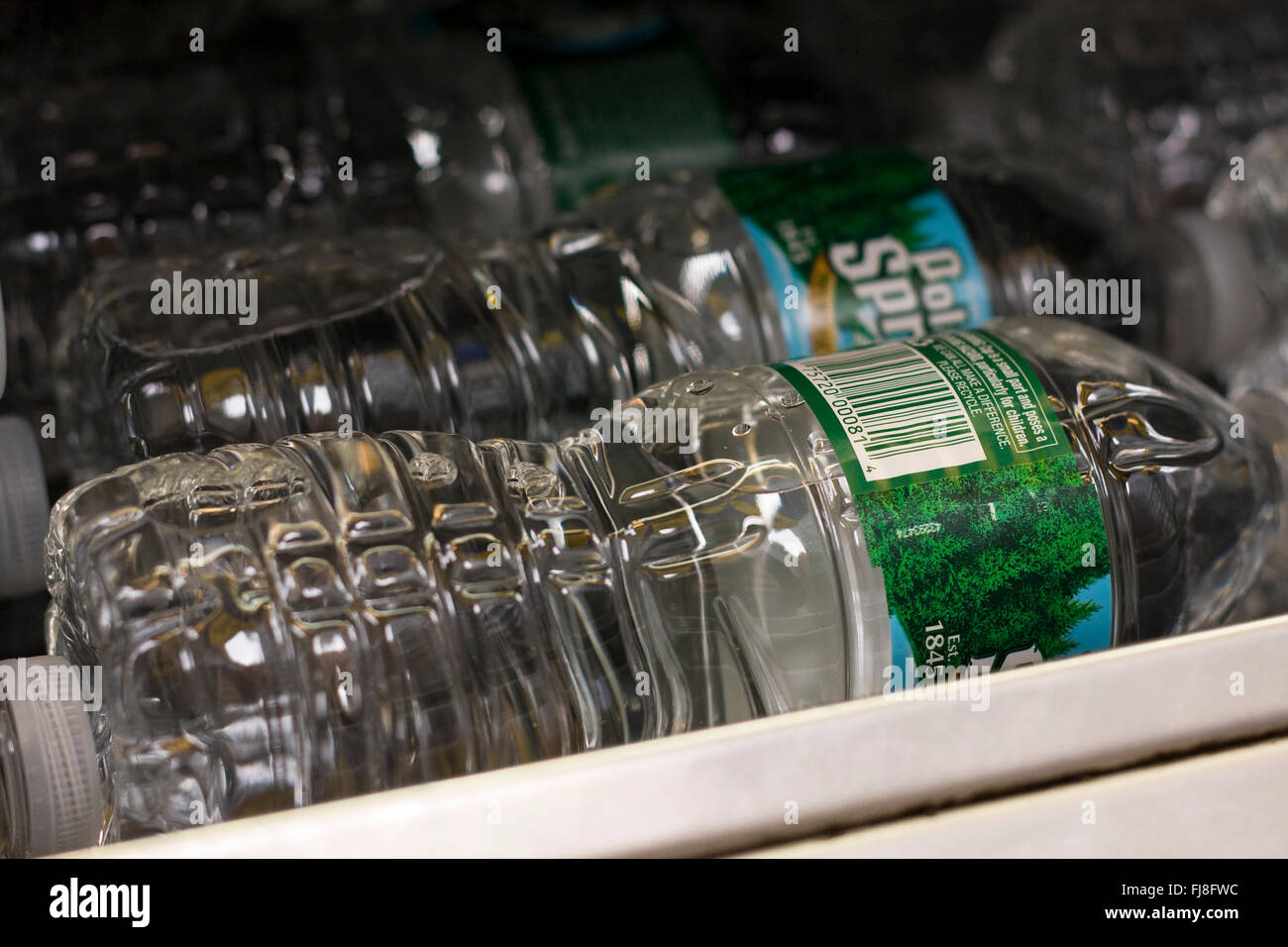 Plastic Water Bottles with UPC symbol stacked in a refrigerated shelf in a retail store Stock Photo