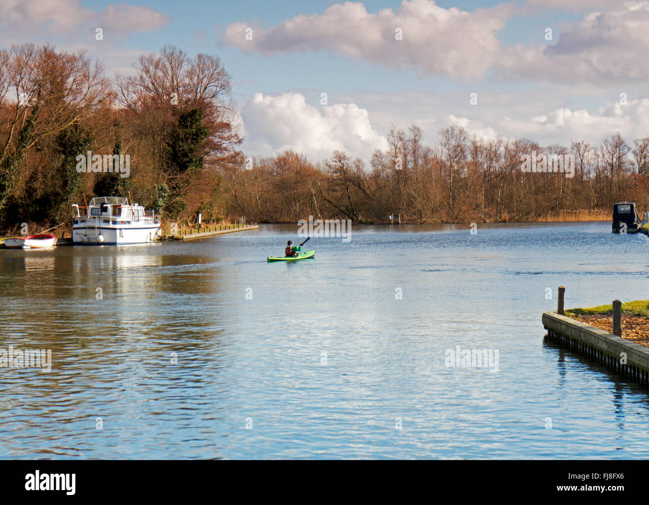 A canoeist paddling away from Barton Turf Staithe on the Norfolk Broads, England, United Kingdom UK. Stock Photo