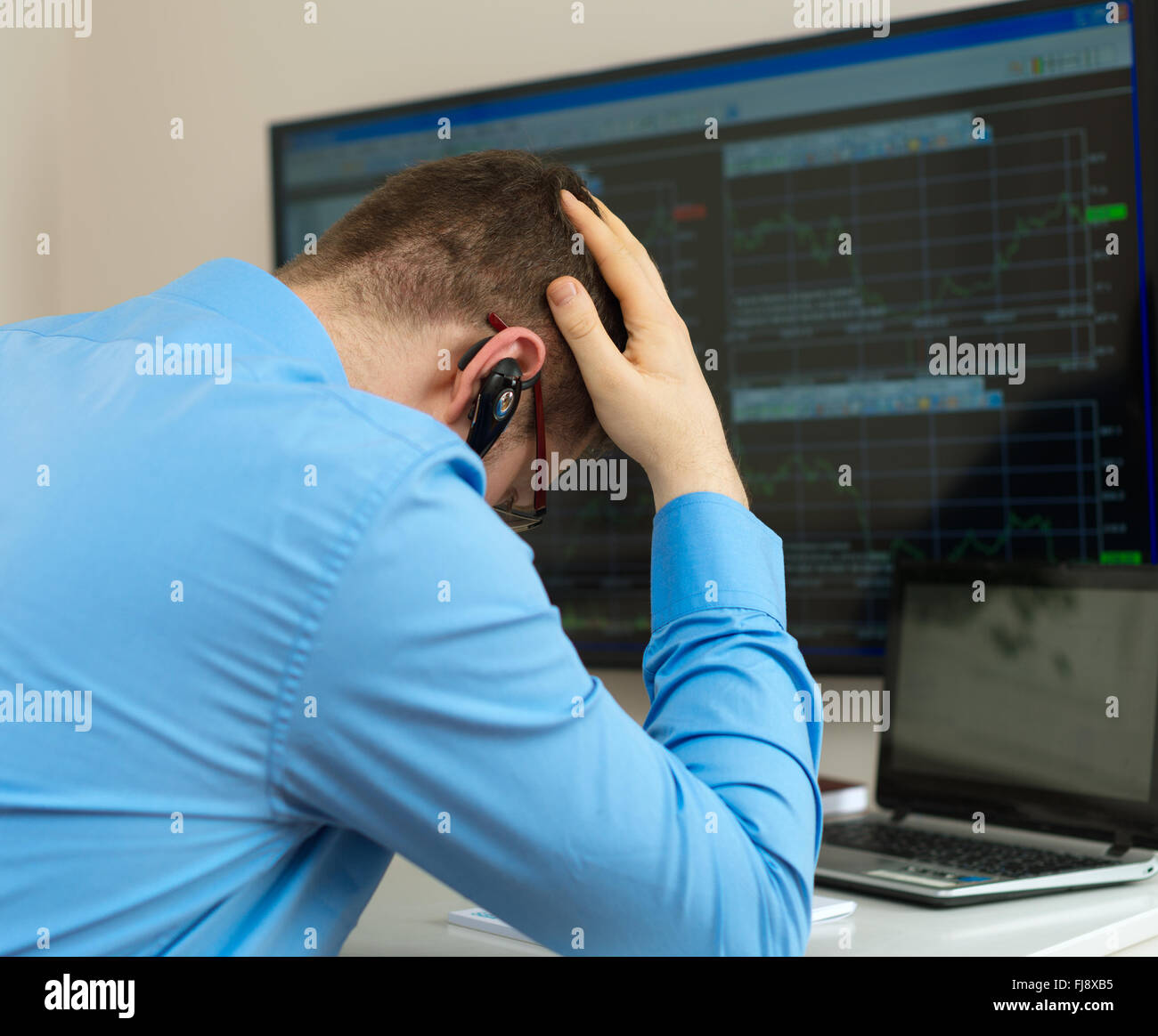Upset stock trader in front of computer. Stock Photo