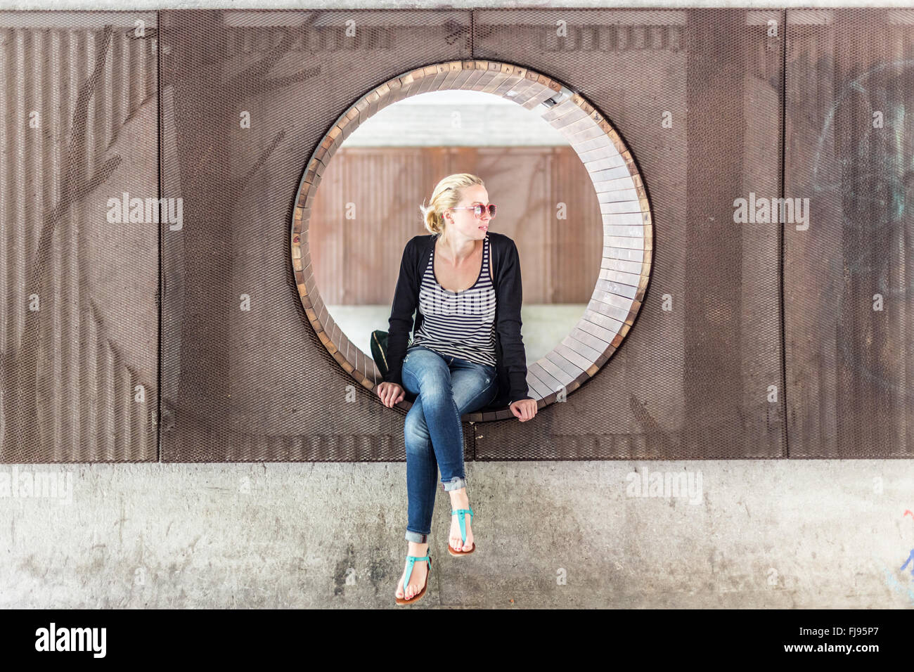 Young urban woman sitting in city park Stock Photo - Alamy