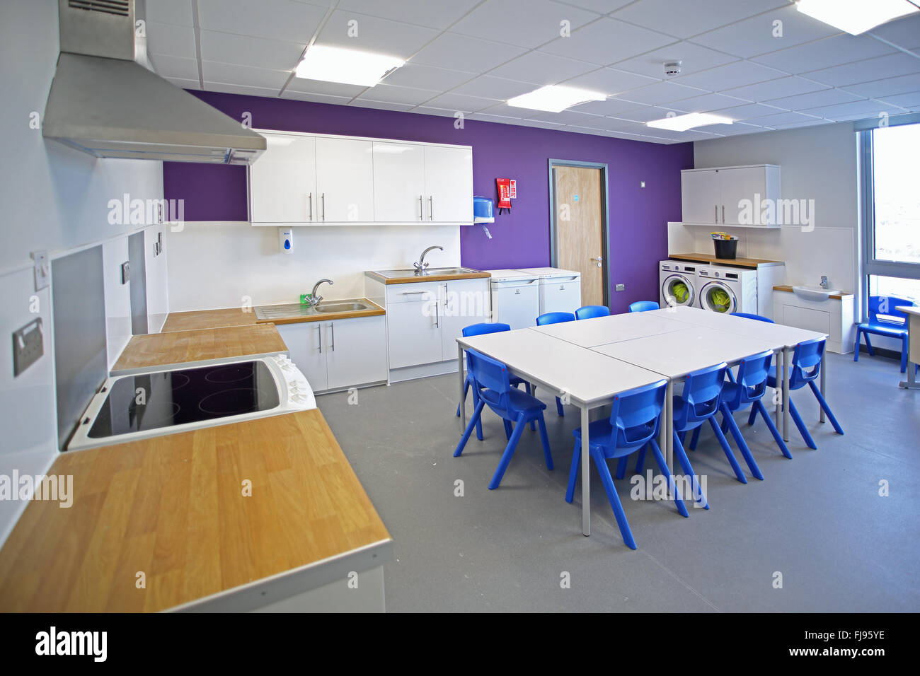 A home economics classroom in a new British Primary School. Shows table, cookers and washing machines Stock Photo