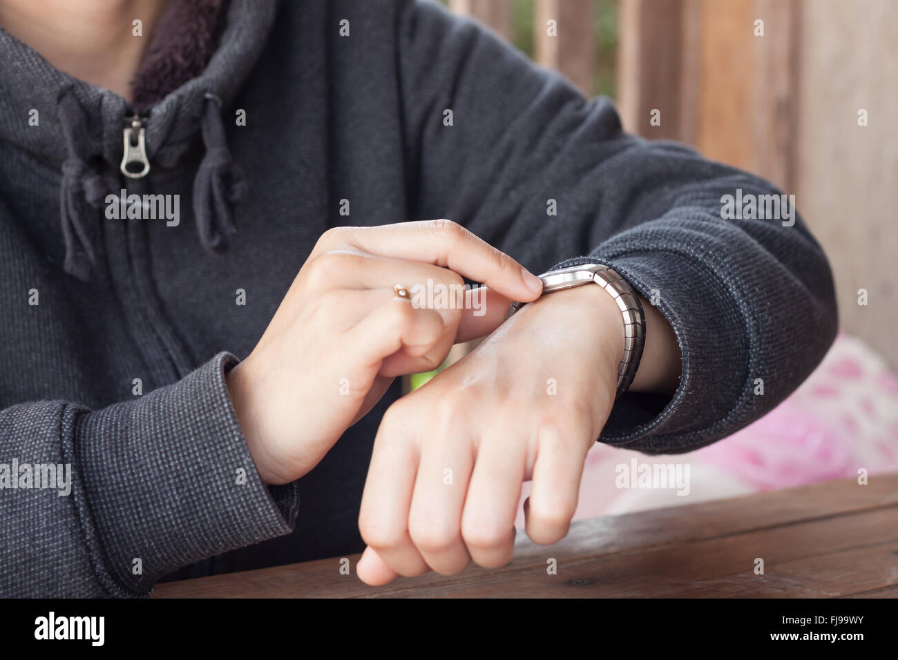 Woman checks the time on a wrist watch, stock photo Stock Photo