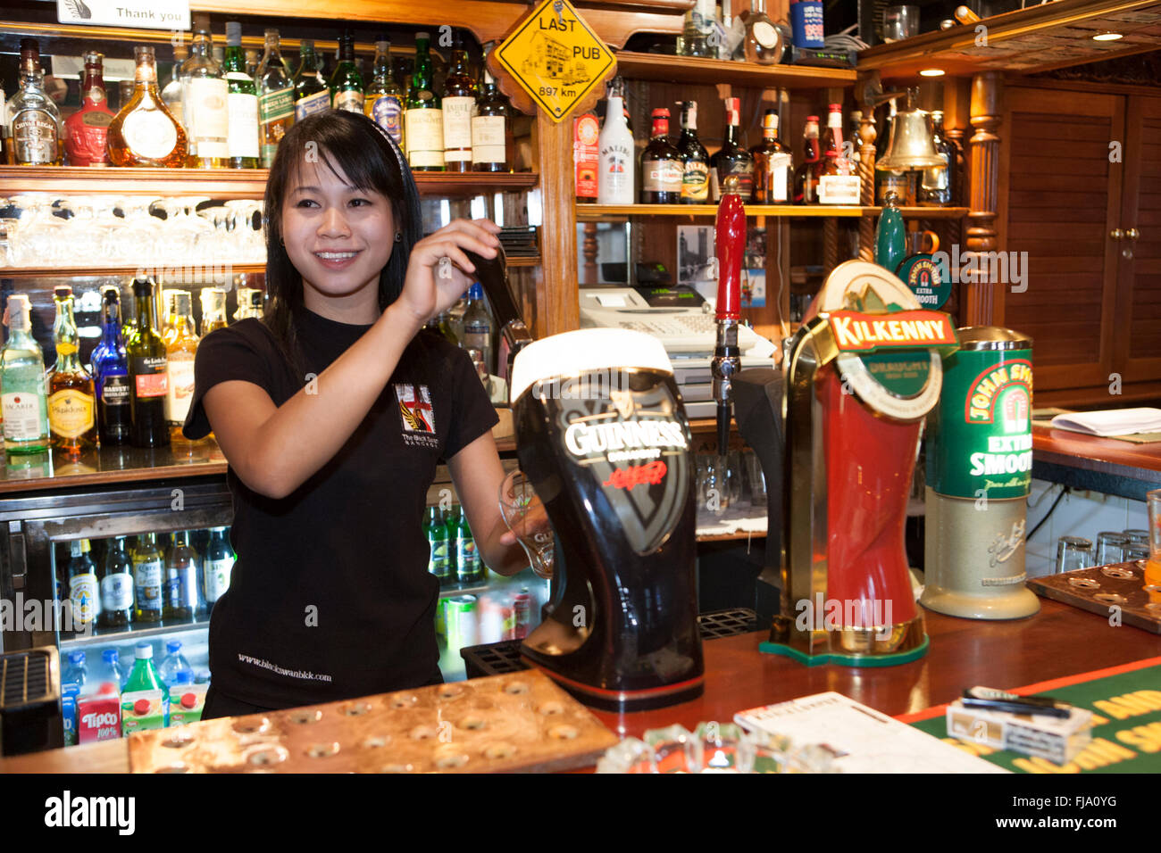 Thai bar tender in a Bangkok English pub Stock Photo