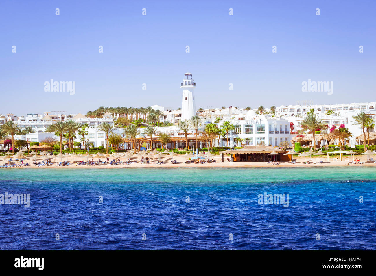 SHARM EL SHEIKH, EGYPT - FEBRUARY 25, 2014: Coastal lighthouse and hotel on beach, luxury vacation for tourists in Red sea Stock Photo
