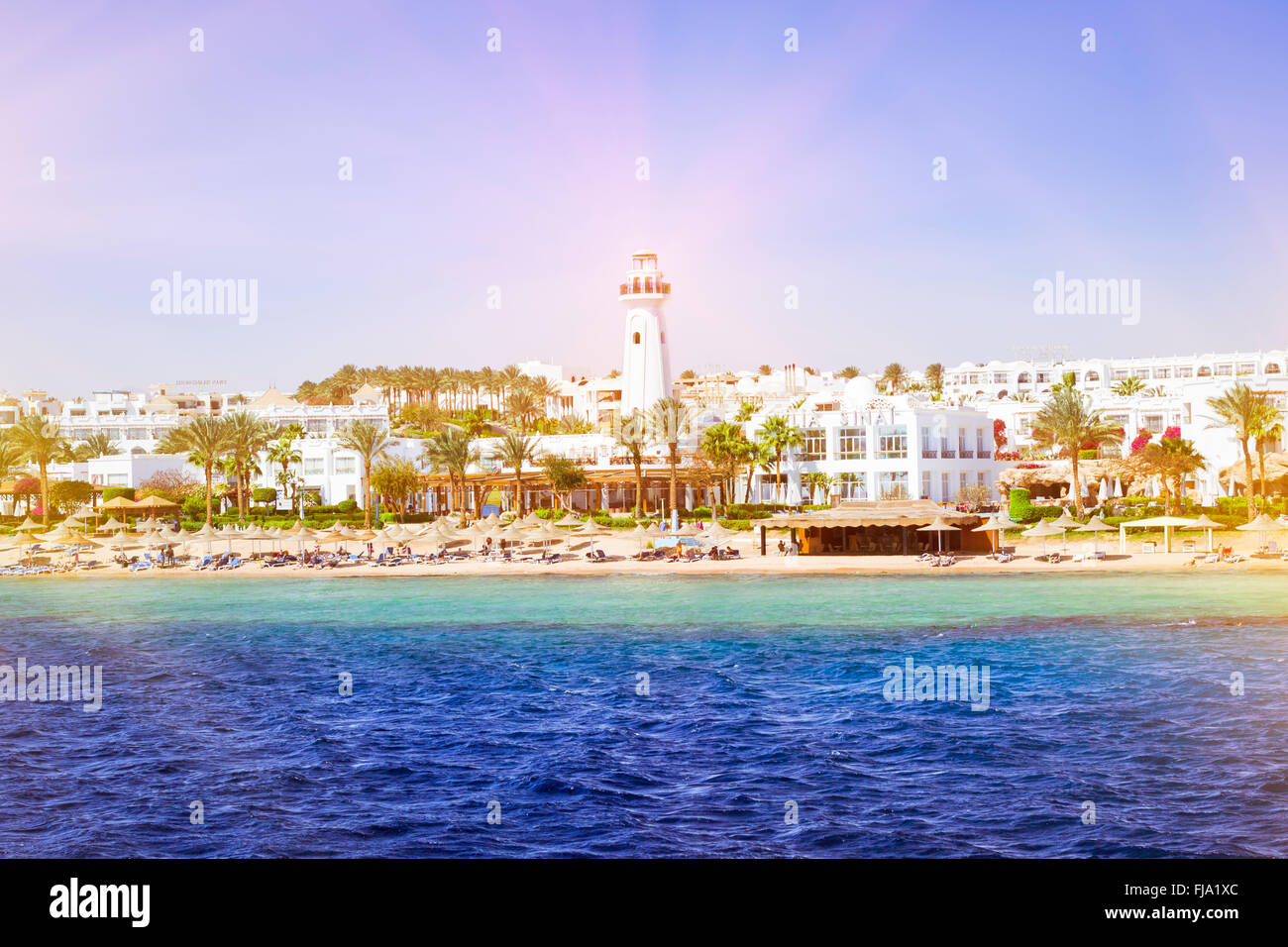 SHARM EL SHEIKH, EGYPT - FEBRUARY 25, 2014: Coastal lighthouse and hotel on beach, luxury vacation for tourists in Red sea Stock Photo