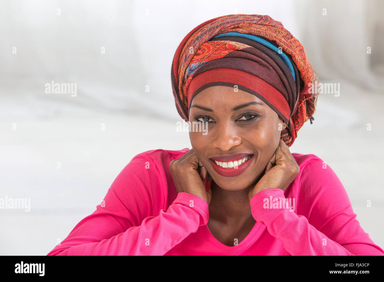 Studio portrait of a mature African happy woman  wearing   headscarf Stock Photo