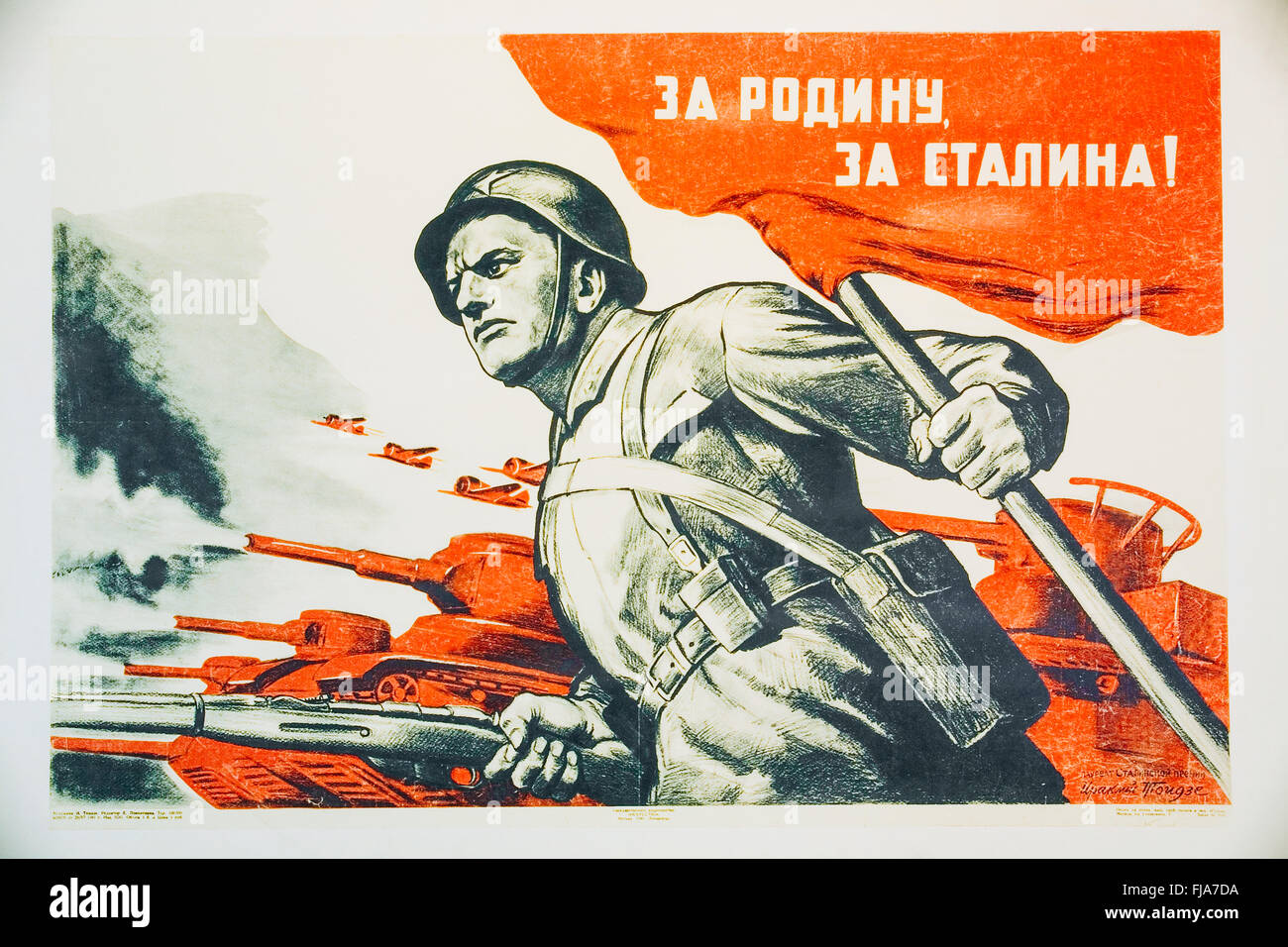 Soviet Russian patriotic propaganda poster from World War II with image of soldier going on attack with rifle and flag Stock Photo