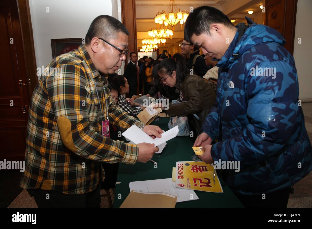 Beijing, China. 1st Mar, 2016. Journalists covering the fourth session of the 12th Chinese People's Political Consultative Conference National Committee get their credentials at the CPPCC auditorium in Beijing, capital of China, March 1, 2016. © Jin Liwang/Xinhua/Alamy Live News Stock Photo