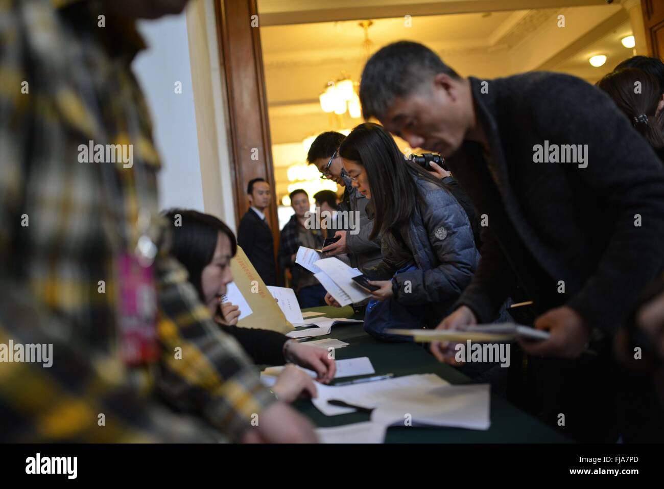 Beijing, China. 1st Mar, 2016. Journalists covering the fourth session of the 12th Chinese People's Political Consultative Conference National Committee get their credentials at the CPPCC auditorium in Beijing, capital of China, March 1, 2016. © Li Renzi/Xinhua/Alamy Live News Stock Photo