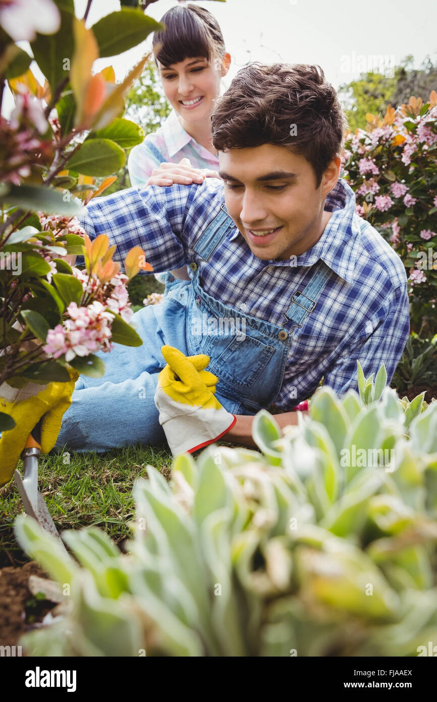 Young couple maintaining plants in garden Stock Photo