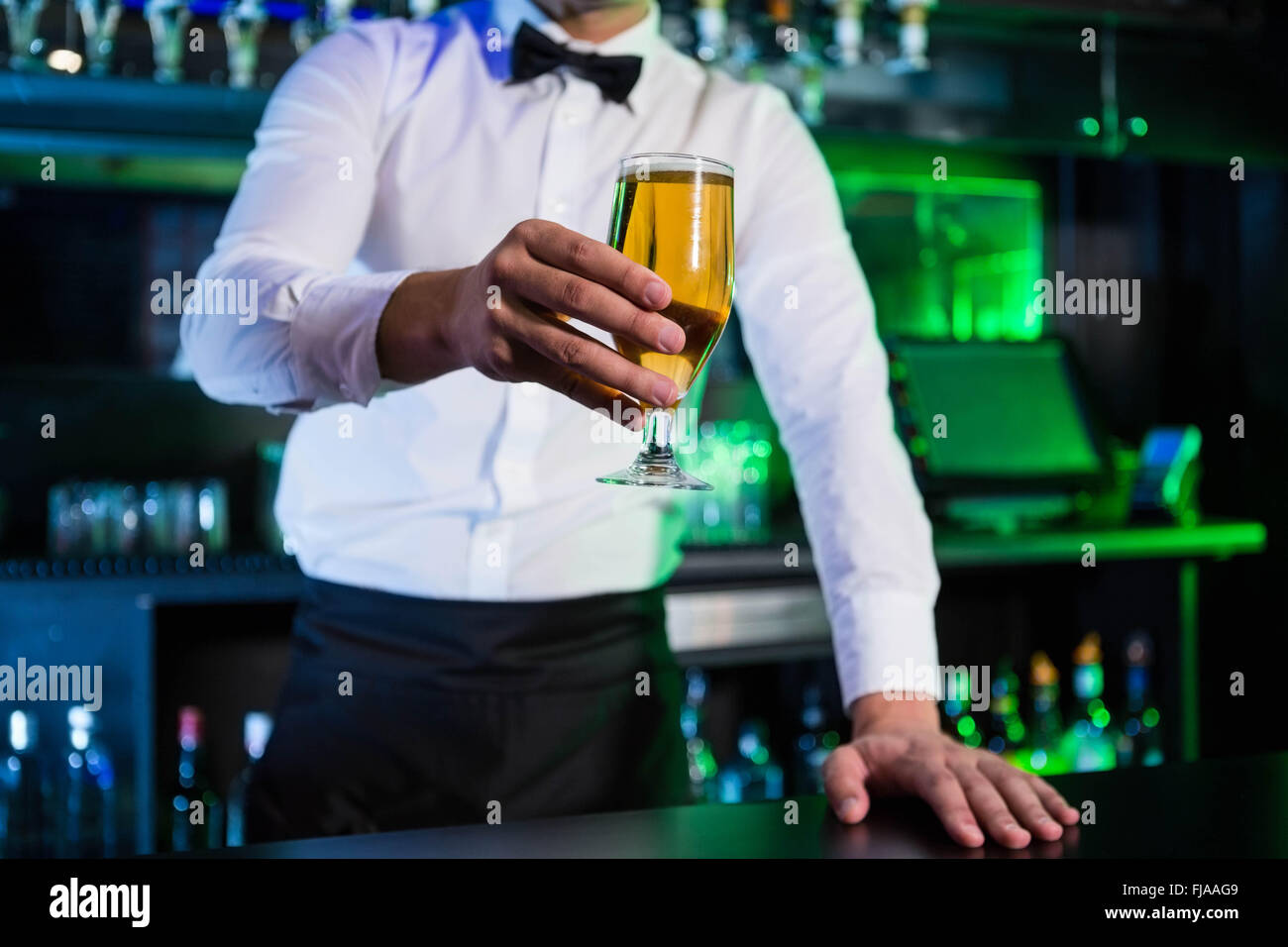Bartender serving a glass of beer Stock Photo