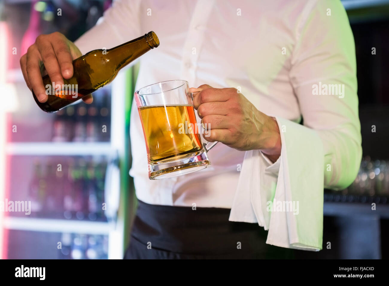 Bartender pouring beer in a pint Stock Photo
