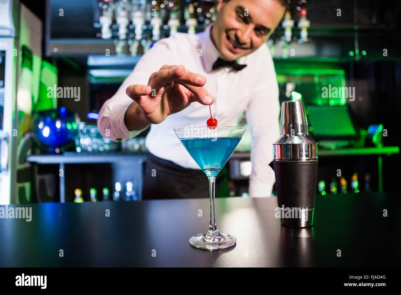 Bartender garnishing cocktail with cherry Stock Photo - Alamy