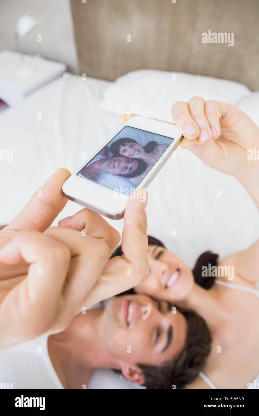 Couple lying on bed and taking a selfie Stock Photo