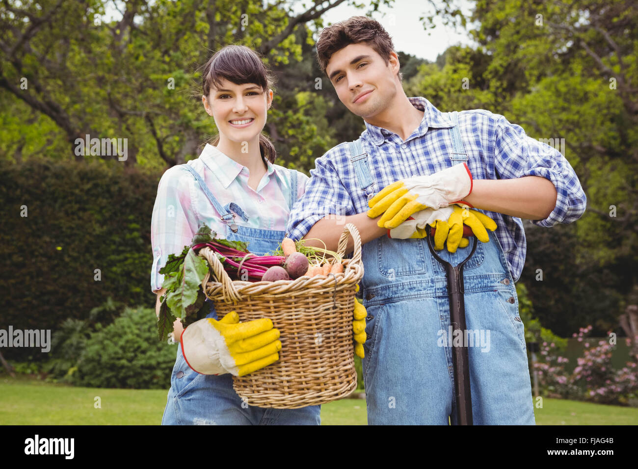 Young couple holding a basket of freshly harvested vegetables Stock Photo