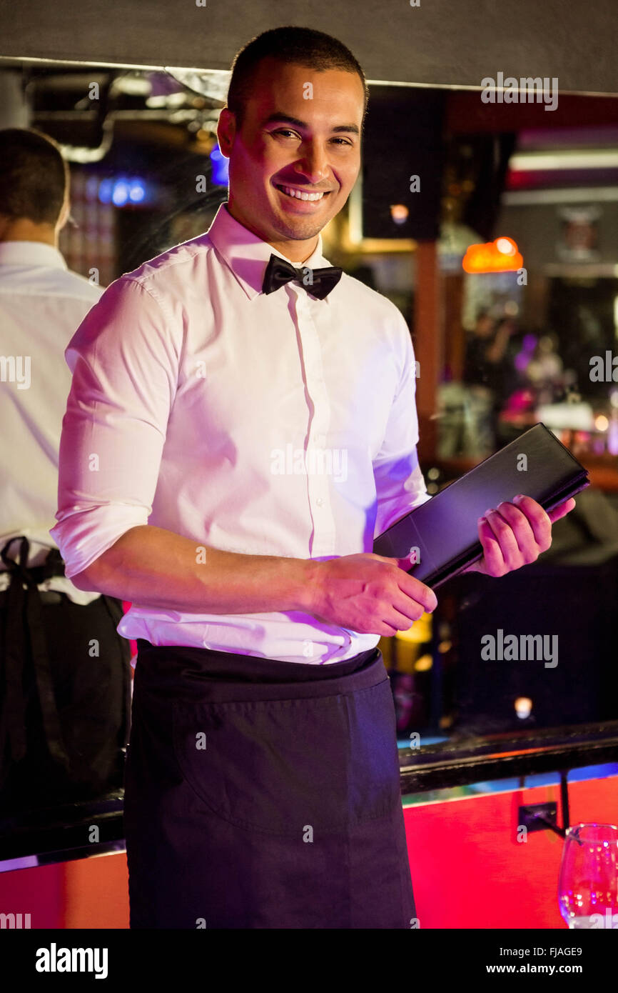 Portrait of waiter standing with a menu card Stock Photo