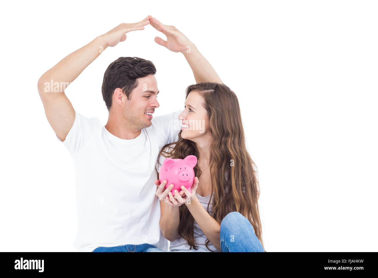 Young couple sitting on floor with piggy bank Stock Photo - Alamy