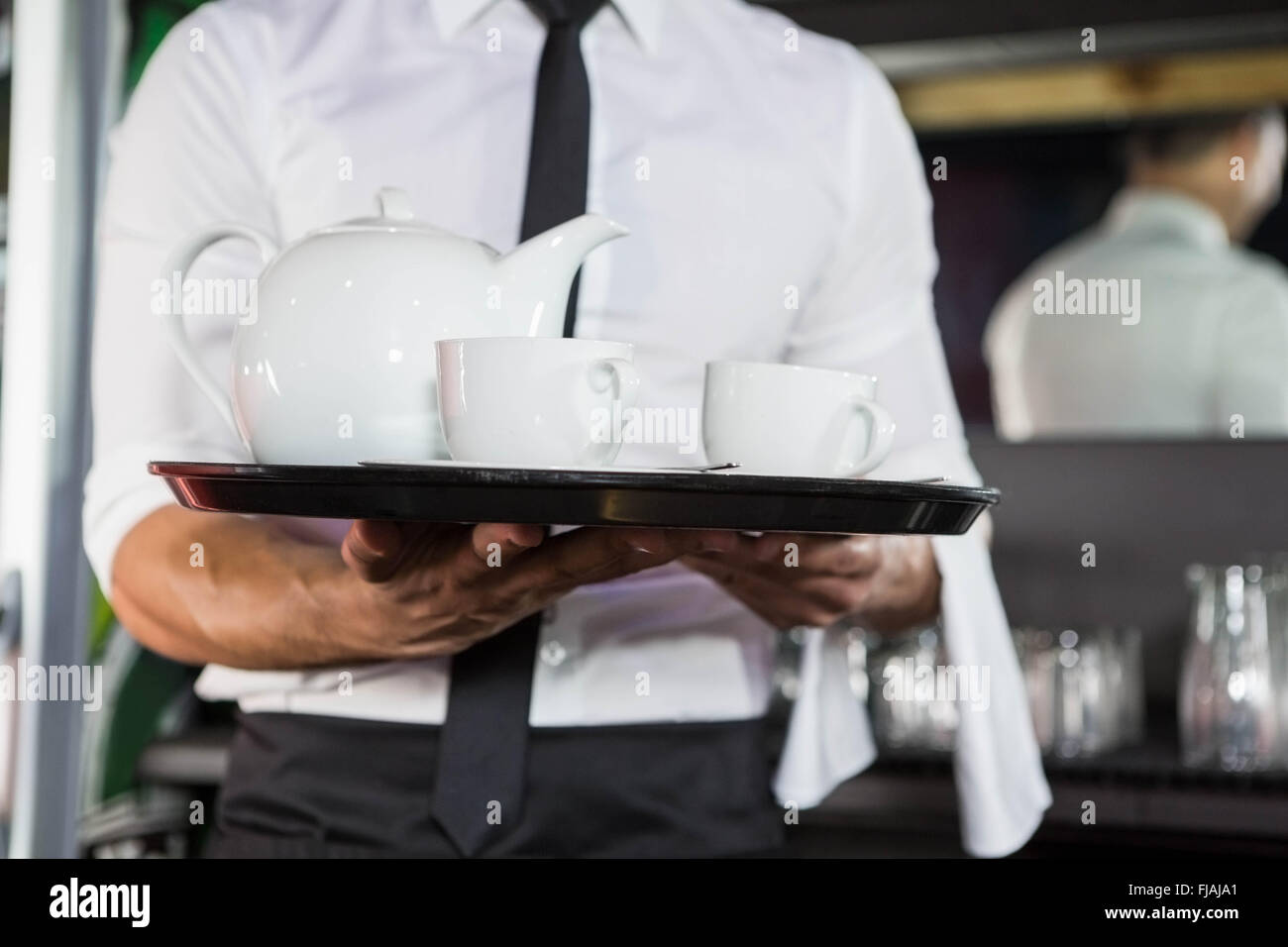 Mid section of waiter serving tea Stock Photo