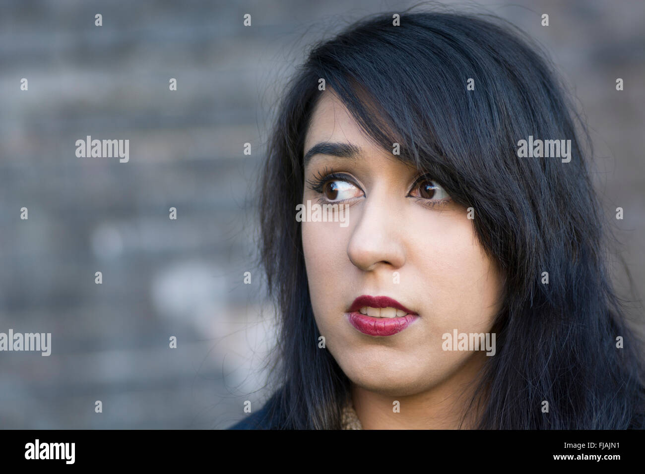 Scared young woman looking away outdoors Stock Photo