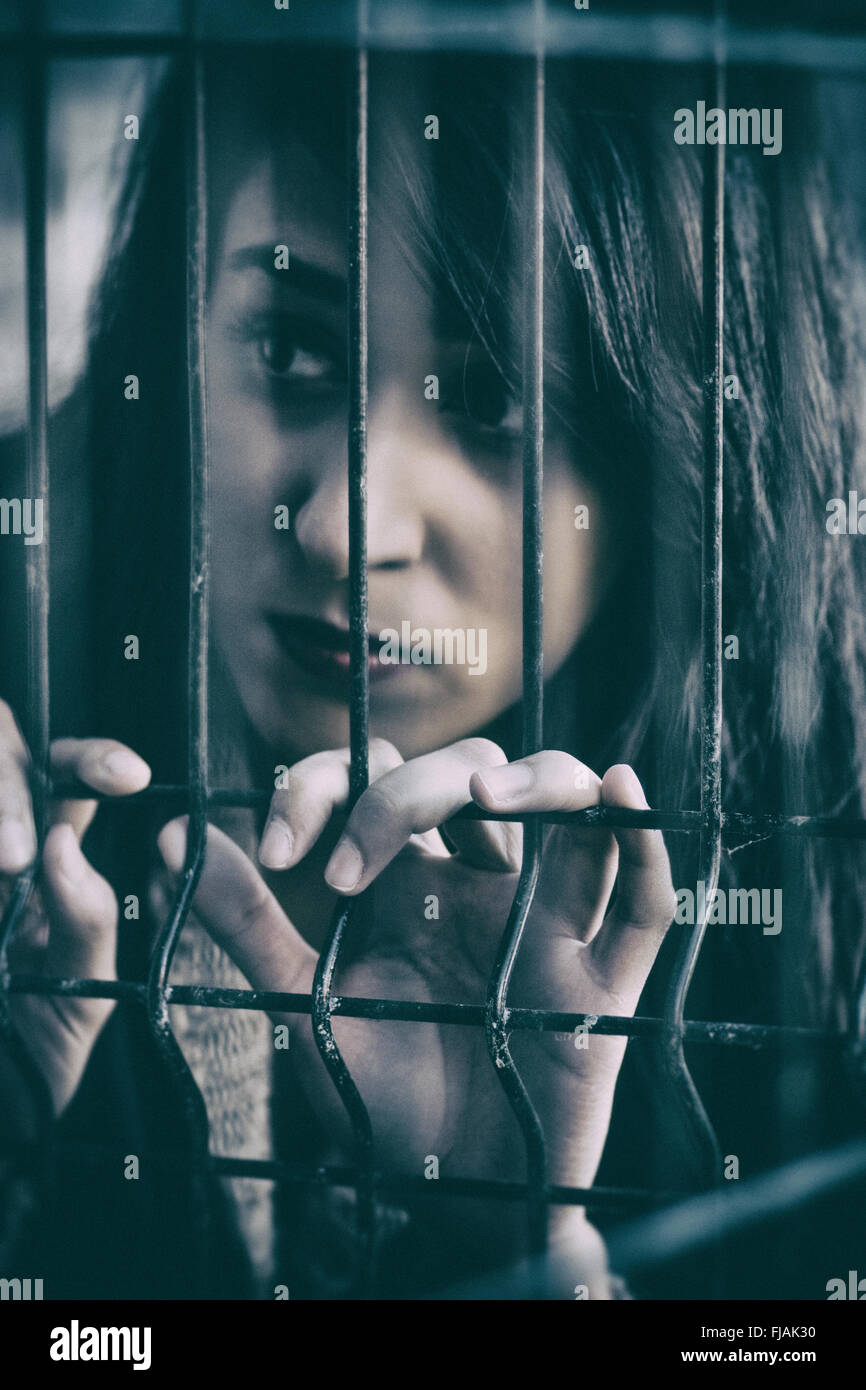 Sad woman behind bars Stock Photo