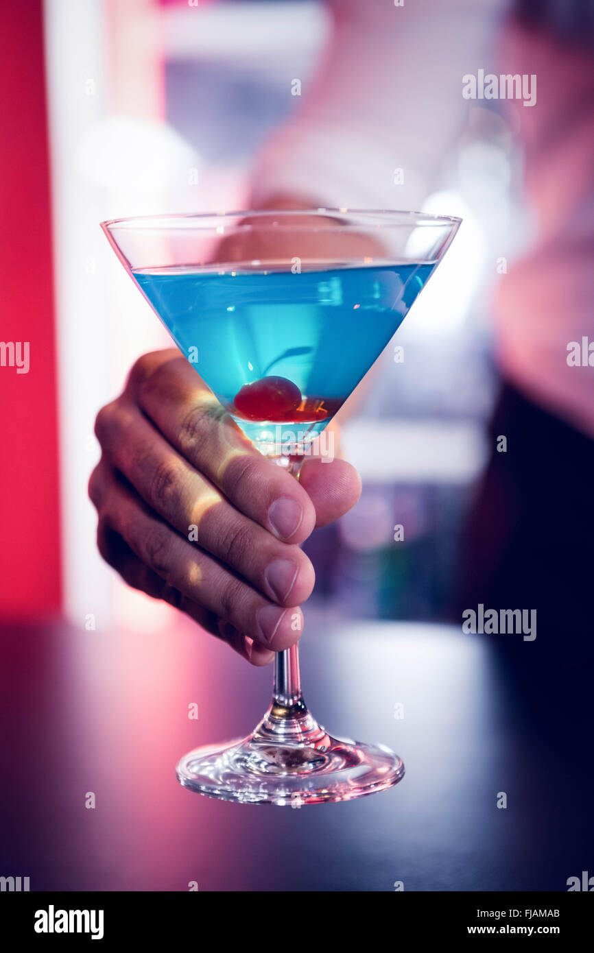 Bartender serving a blue martini Stock Photo