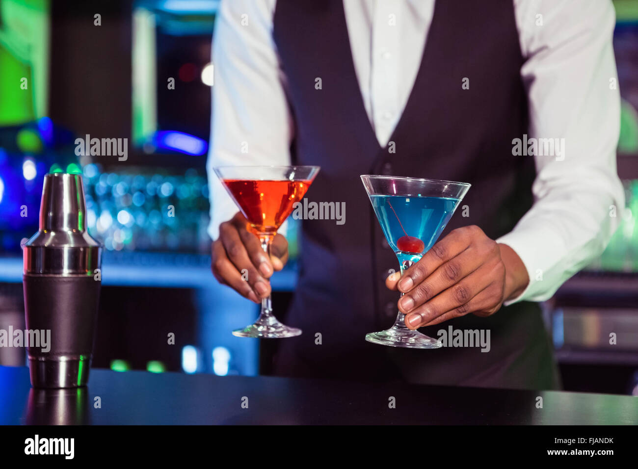 Bartender serving blue and orange cocktail drinks Stock Photo