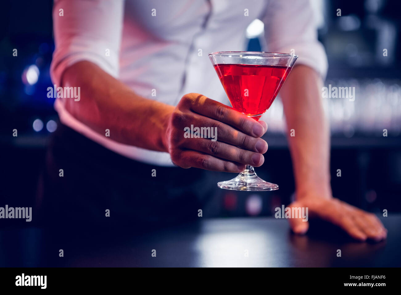 Bartender serving a red martini Stock Photo