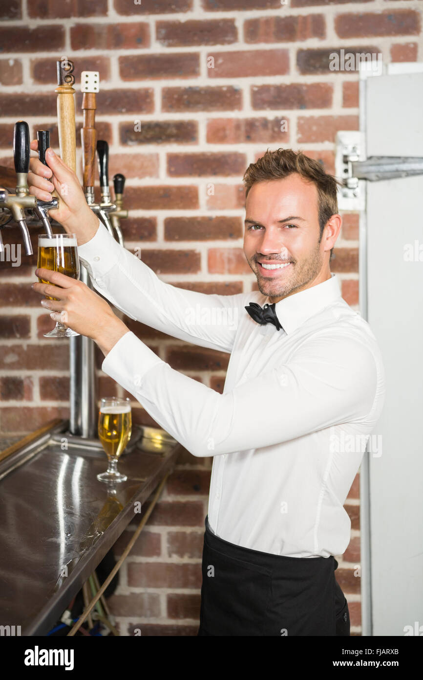 Handsome bar tender pouring a pint Stock Photo