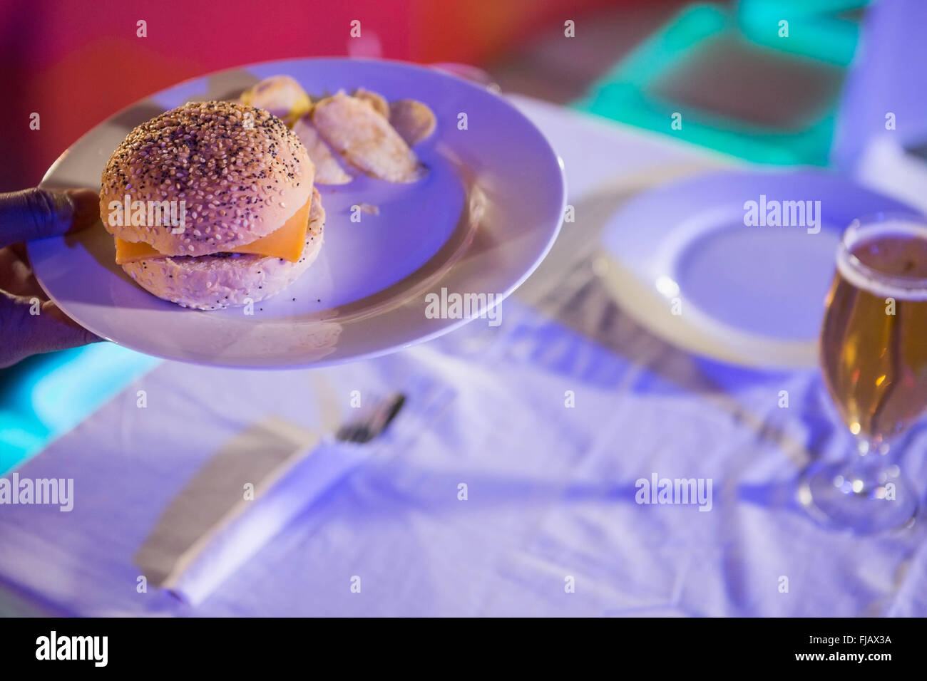 Plate of burger and beer glass on table Stock Photo