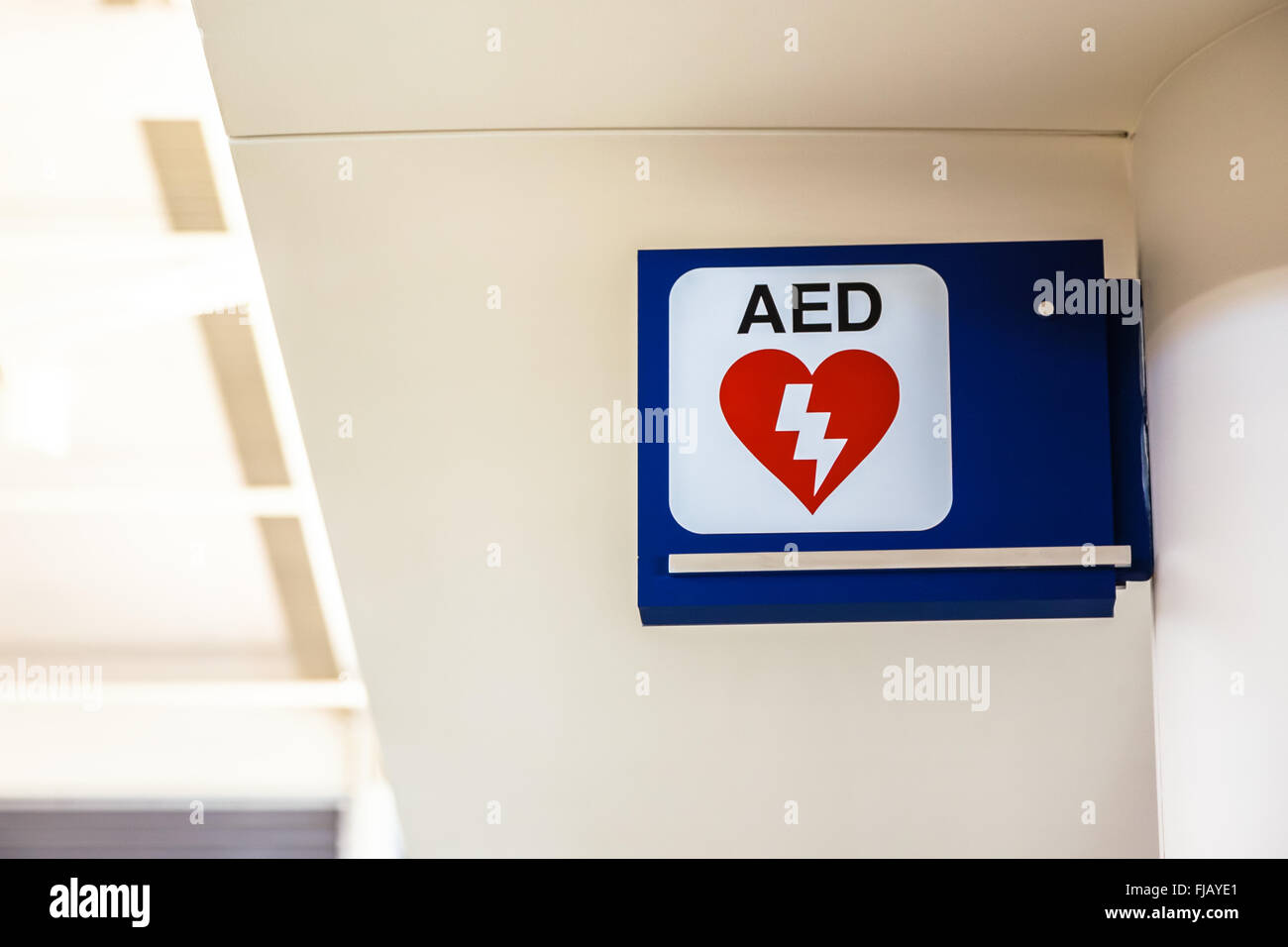 Automated External Defibrillator AED sign mounted to a wall at an airport. Stock Photo