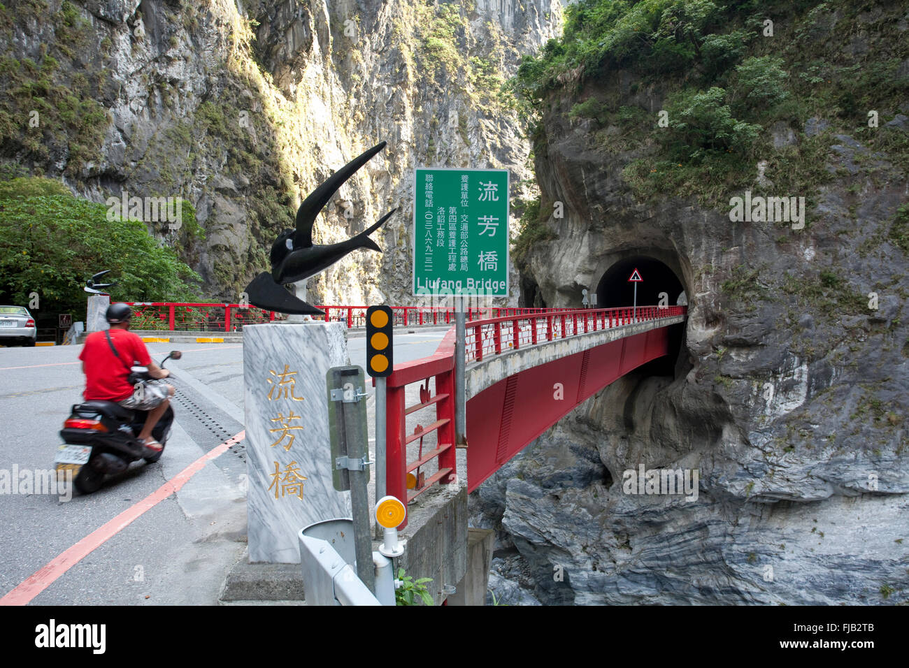 Motorbike rider passing through the Taroko gorge on the Central Cross Island Highway, Taiwan Stock Photo