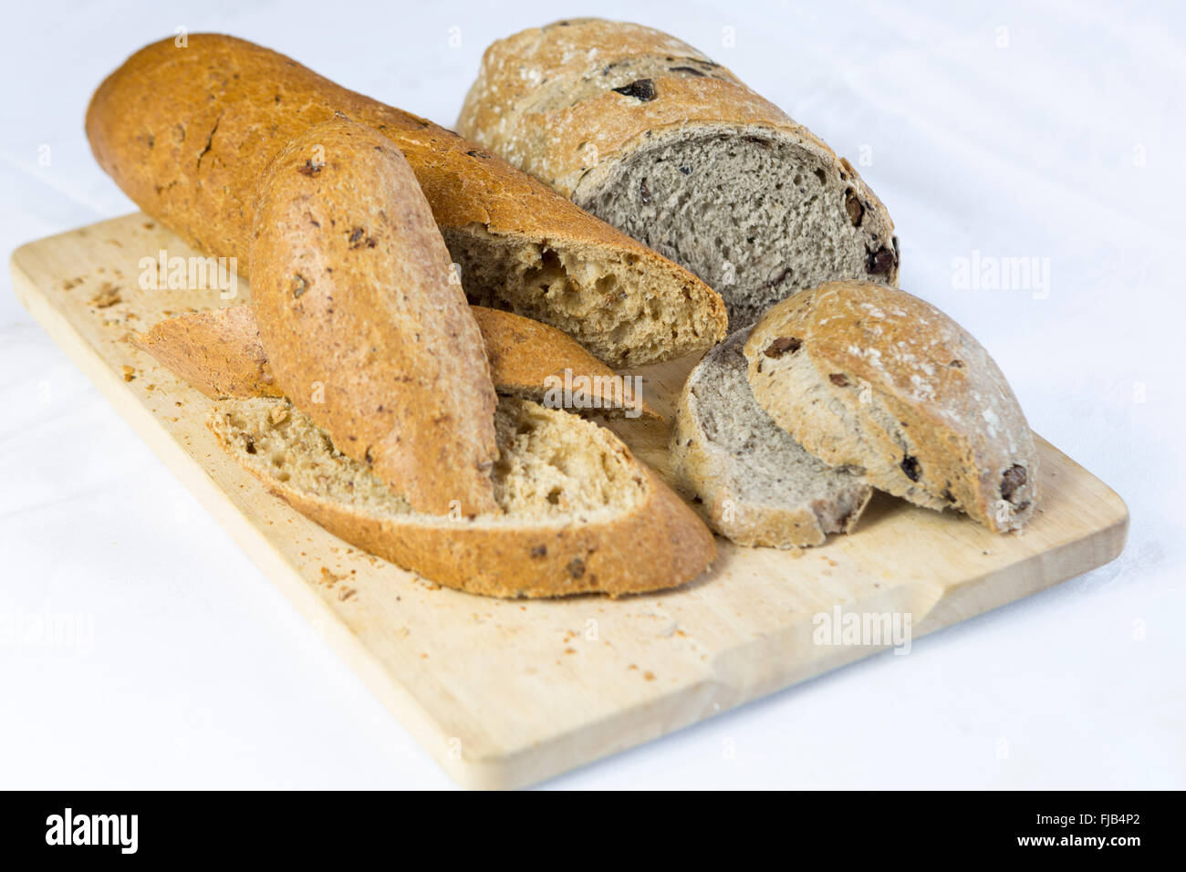 Cut bread on a wooden bread board, white background Stock Photo - Alamy