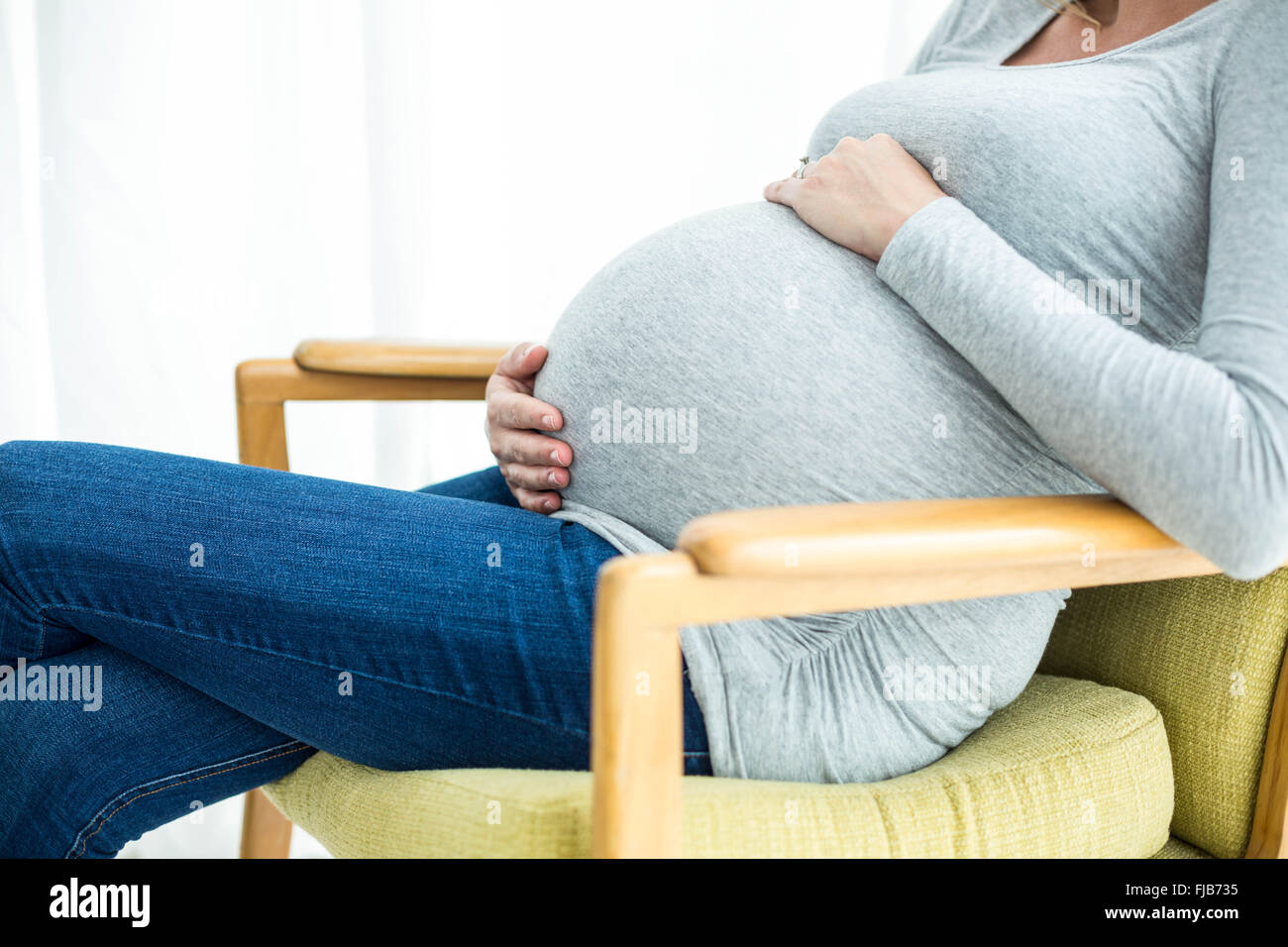 Pregnant woman holding her stomach Stock Photo - Alamy