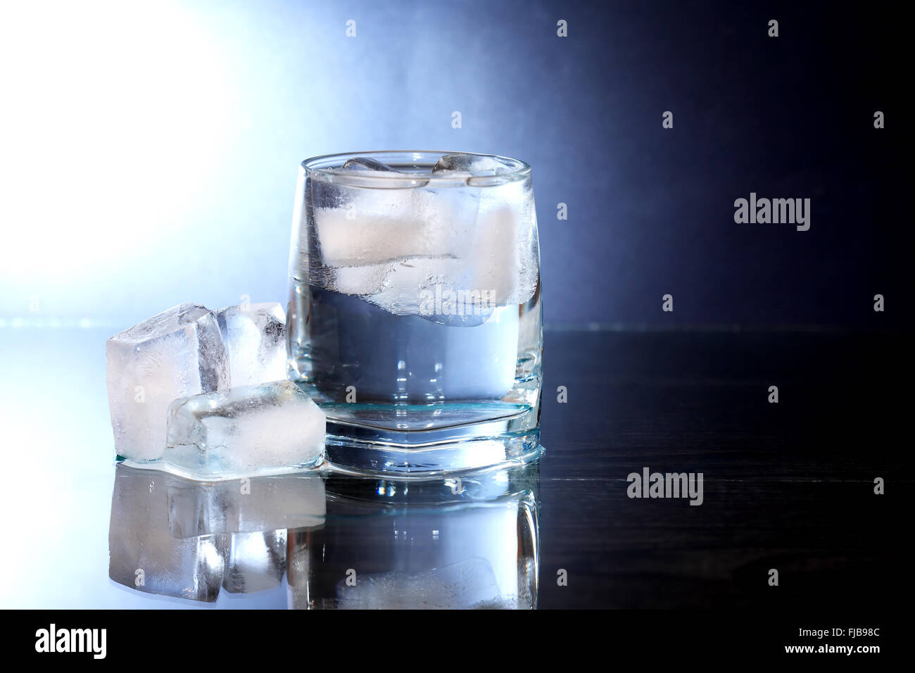 Glass of water with ice cubes on nice dark background Stock Photo - Alamy