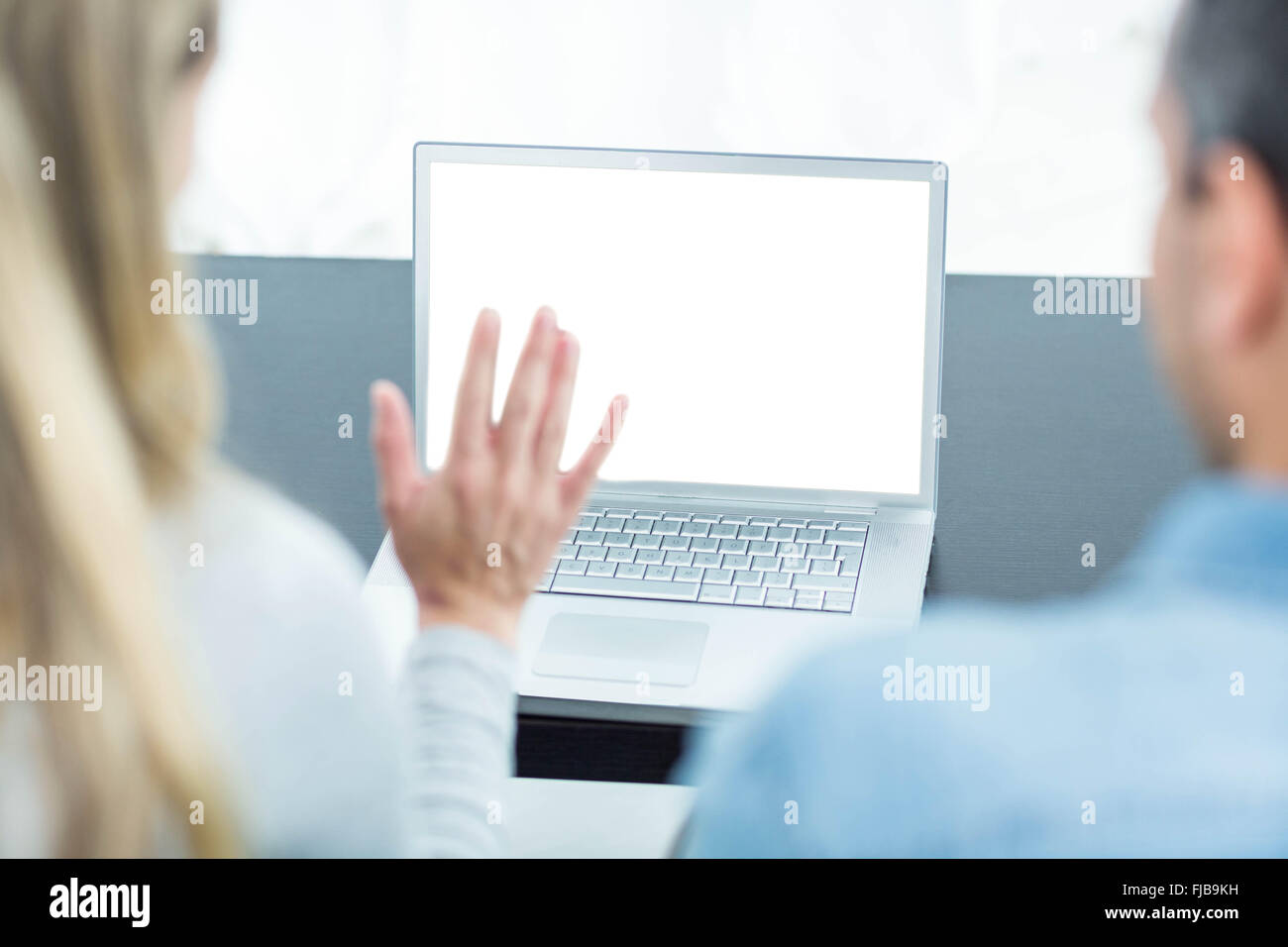 Couple using laptop in living room Stock Photo - Alamy
