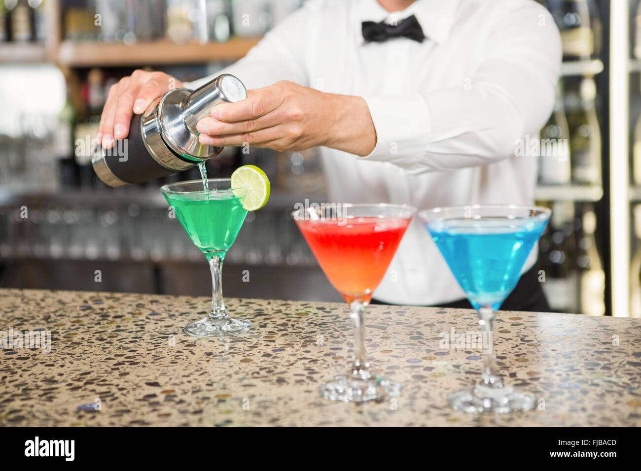 Handsome barman pouring cocktails Stock Photo