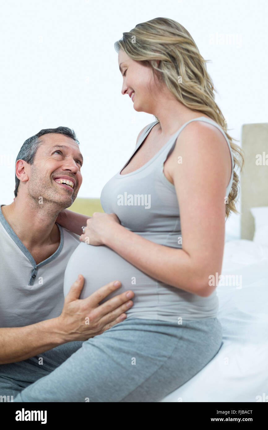 Expecting couple lying on bed and chatting Stock Photo
