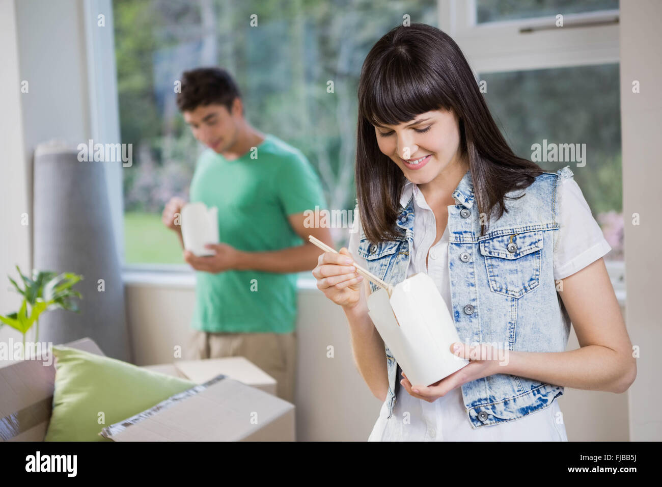 Portrait of young woman eating noodles at home Stock Photo