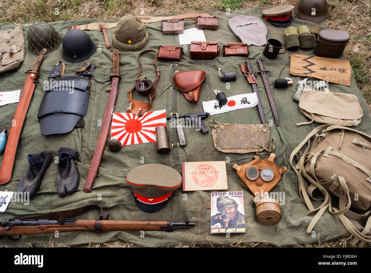 War and Peace show, England. Display of WW2 Japanese Imperial Army equipment laid-out on groundsheet. Includes gas mask, helmets, armour and caps. Stock Photo