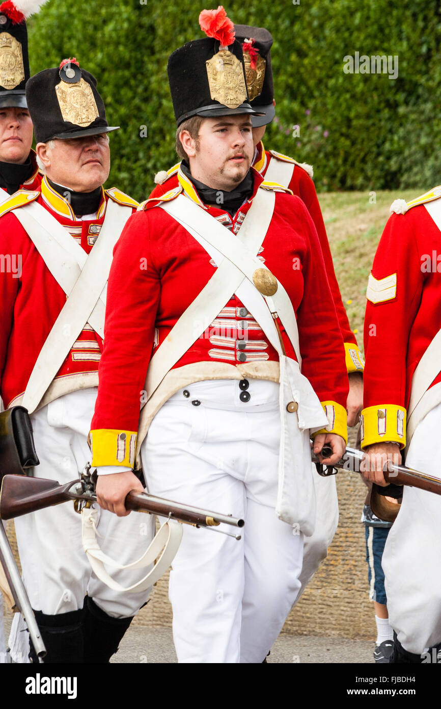 Napoleonic wars re-enactment. British Redcoats, 1st foot regiment Grenadier Guards, marching in column, while holding rifles at the side. Close up. Stock Photo